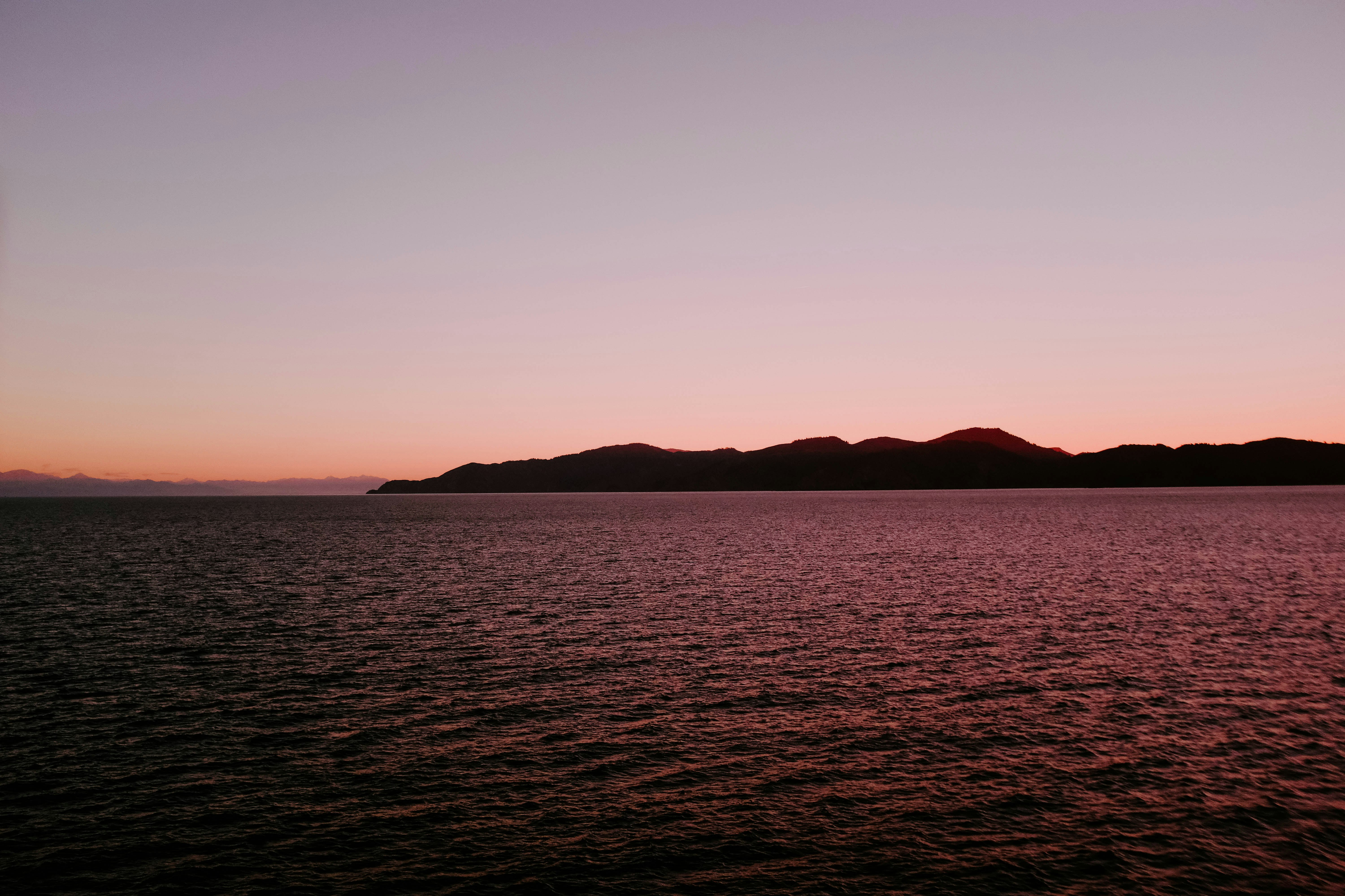 landscape photography of body of water beside mountain